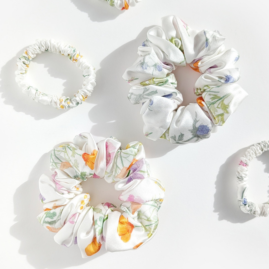 Set of five mei flower floral scrunchies on a white background