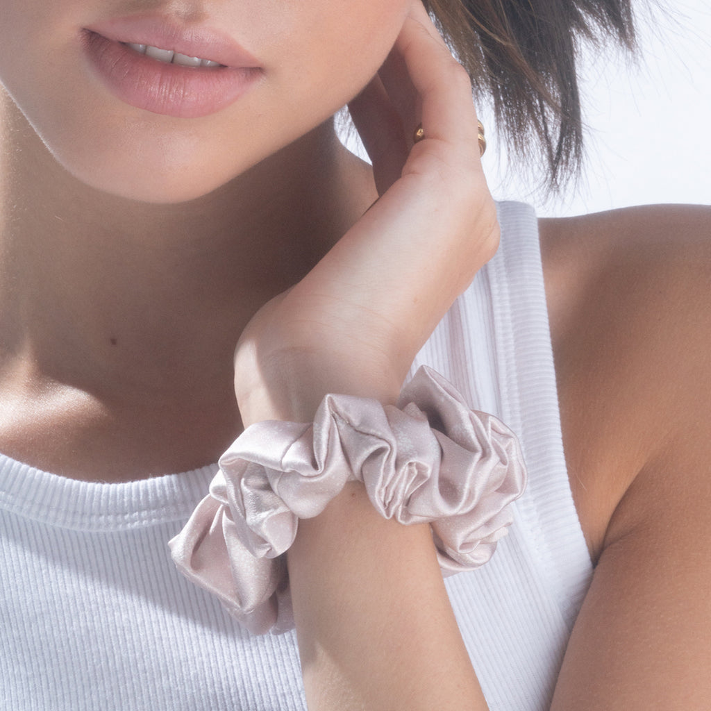A Moon Dust silk scrunchie on a woman's wrist