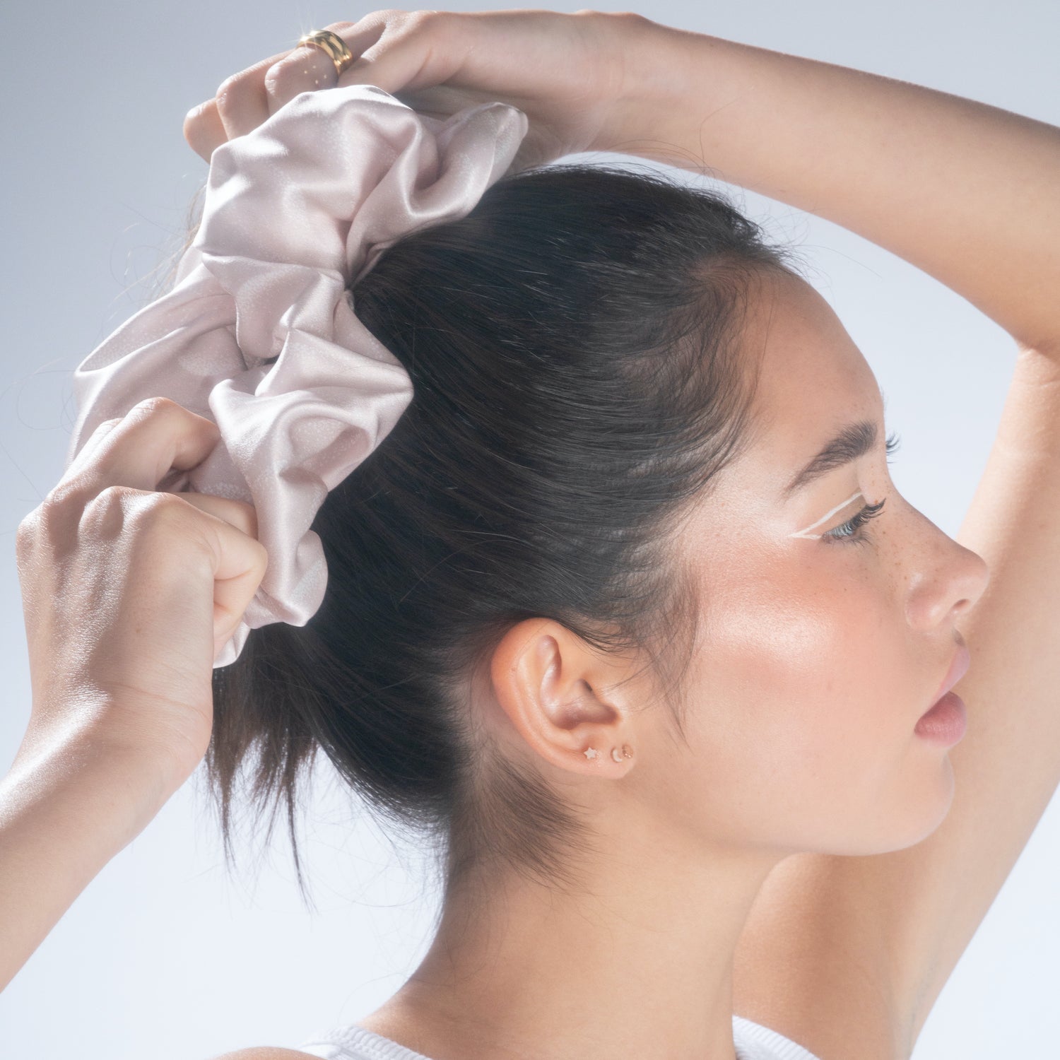 A woman styling a lilac jumbo silk scrunchie